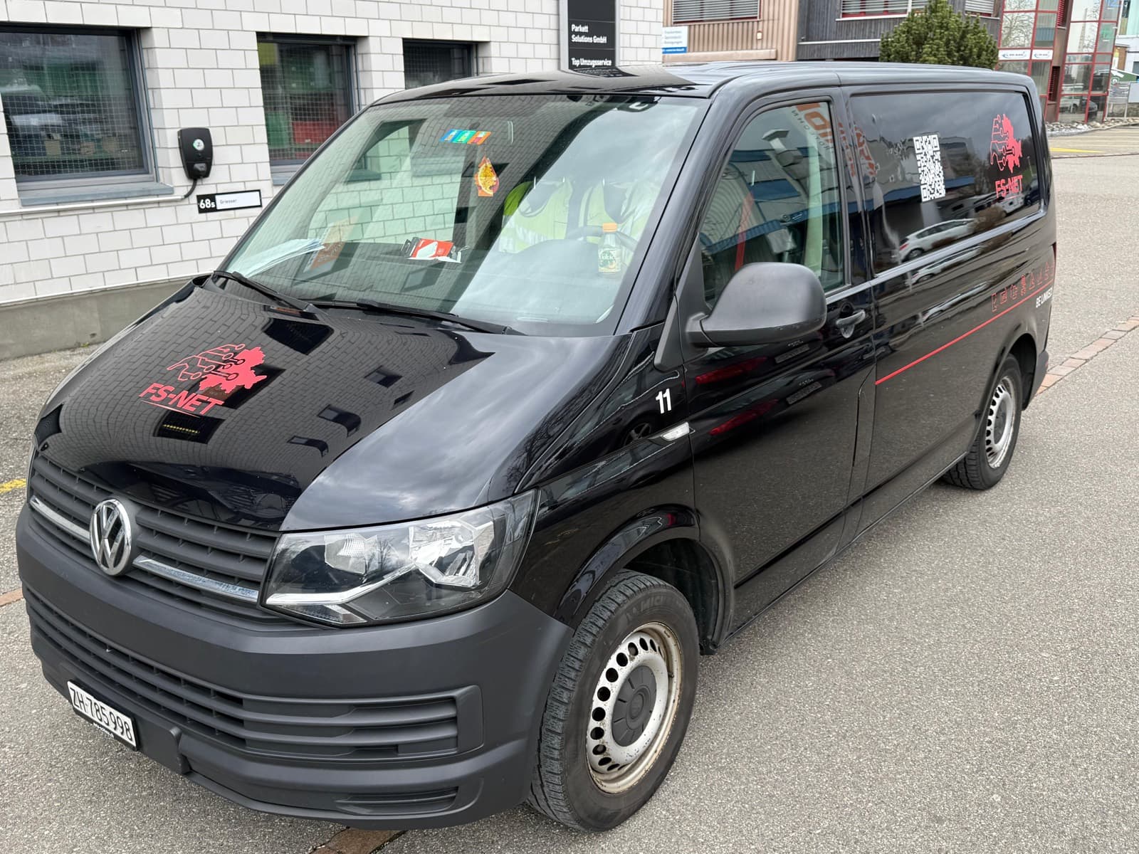 Schwarzer Transporter mit roter Beschriftung